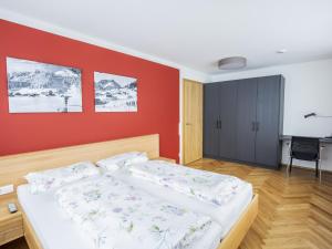 a bedroom with two beds and a red wall at Chalet Alpenluft in Hirschegg