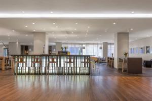 un hall de bureau avec un bar et des tabourets dans l'établissement AC Hotel Iberia Las Palmas by Marriott, à Las Palmas de Gran Canaria