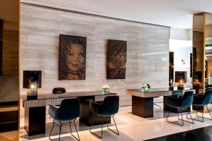a lobby with a bar with chairs and a fireplace at Le Méridien Vienna in Vienna