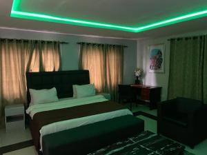 a bedroom with a bed with a green light on it at Suite Subzero in Lagos