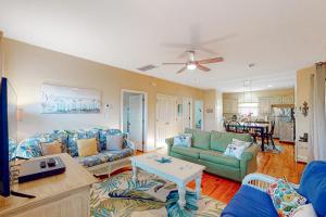 uma sala de estar com sofás azuis e uma mesa em The Rookery #3002 em Gulf Shores
