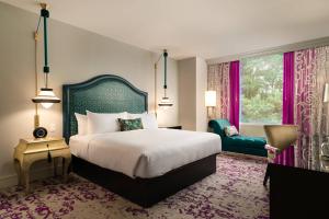 a bedroom with a bed and a chair and a window at Grand Bohemian Hotel Charlotte, Autograph Collection in Charlotte