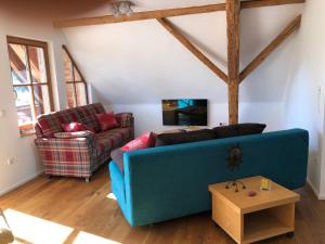 a living room with a blue couch and a table at Fewo Pflaumi 1 in Gunzenhausen