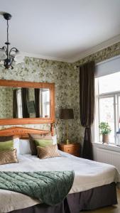 a bedroom with a large bed and a window at Hennickehammars Herrgård in Filipstad