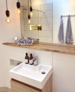 een badkamer met een witte wastafel en een spiegel bij The Estuary in Dundee