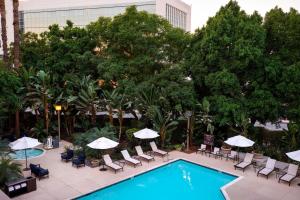 una vista aérea de una piscina con sillas y sombrillas en Fullerton Marriott at California State University, en Fullerton