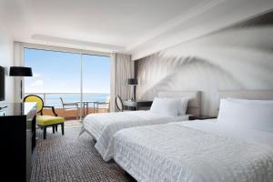 a hotel room with two beds and a view of the ocean at Le Méridien Beach Plaza in Monte Carlo