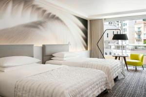 a hotel room with two beds and a window at Le Méridien Beach Plaza in Monte Carlo