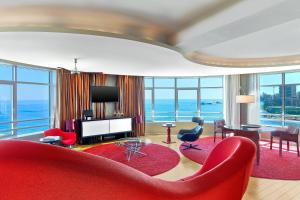 a living room with a red couch and a television at Le Méridien Beach Plaza in Monte Carlo