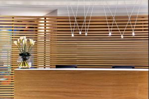 a wooden wall with a vase of flowers on a counter at Le Méridien Beach Plaza in Monte Carlo
