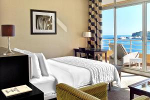 a hotel room with a bed and a view of the ocean at Le Méridien Beach Plaza in Monte Carlo +37 photos
