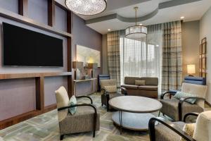 uma sala de estar com uma televisão e uma mesa e cadeiras em TownePlace Suites Houston I-10 East em Houston