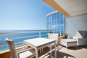 a balcony with a table and chairs and the ocean at Le Méridien Beach Plaza in Monte Carlo