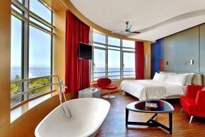 a hotel room with a bed and red chairs at Le Méridien Beach Plaza in Monte Carlo