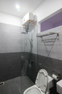 a bathroom with a toilet and a glass shower stall at Dory Homestay in Hue