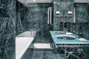 La salle de bains est pourvue d'un lavabo, d'une douche et d'une baignoire. dans l'établissement AC Hotel La Rioja by Marriott, à Logroño
