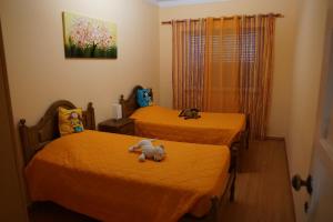 duas camas com bichos de peluche num quarto em Herois Apartment em Damaia