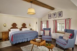 a bedroom with a bed and two chairs at Hotel Goldener Hirsch, A Luxury Collection Hotel, Salzburg in Salzburg +54 photos