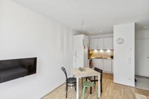 een keuken en eetkamer met een tafel en stoelen bij Arbio I Ding Design Apartments in Brigittenau Vienna in Wenen