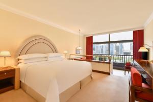 a bedroom with a white bed and a large window at Sheraton Grand Doha Resort & Convention Hotel in Doha