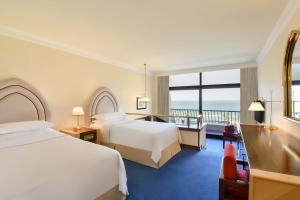 מיטה או מיטות בחדר ב-Sheraton Grand Doha Resort & Convention Hotel