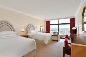 מיטה או מיטות בחדר ב-Sheraton Grand Doha Resort & Convention Hotel