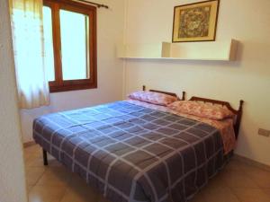 1 dormitorio con 1 cama con manta azul y ventana en Villetta Best Vacation Ever, Costa Rei, en Costa Rei