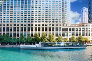 um barco na água em frente a um grande edifício em Sheraton Grand Chicago Riverwalk em Chicago