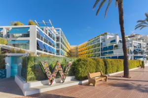 un banco frente a un edificio con la letra v en W Ibiza, en Santa Eulària des Riu