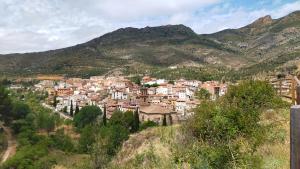 un pueblo en una colina con montañas en el fondo en Peñas de Arnedillo, en Arnedillo