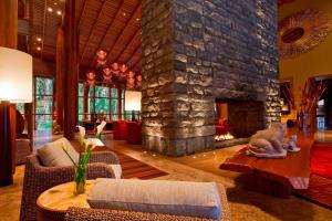 a living room with a large stone fireplace at Tambo del Inka, a Luxury Collection Resort & Spa, Valle Sagrado in Urubamba