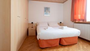 una camera da letto con un grande letto bianco e ottomane arancioni di Italianway - Ripa Fontana 1 Bilo a Valdidentro