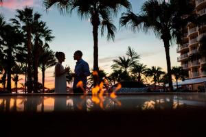 a bride and groom standing next to a pool at a resort at JW Marriott Marco Island Beach Resort in Marco Island