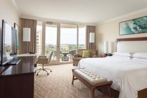 a hotel room with a bed and a desk and a living room at JW Marriott Marco Island Beach Resort in Marco Island