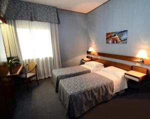 a hotel room with two beds and a window at Hotel Al Sant'Andrea in Sarzana