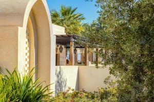 a house with an arched window and trees at Al Wathba, a Luxury Collection Desert Resort & Spa, Abu Dhabi in Abu Dhabi