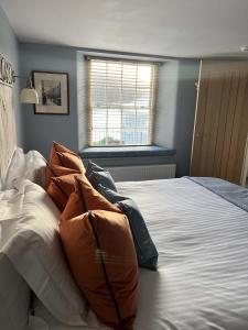 una camera da letto con un letto grande con cuscini sopra di Oystercatcher a Fowey