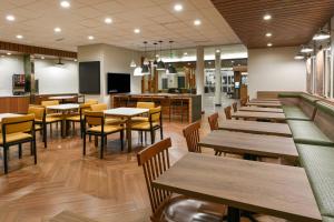 a restaurant with wooden tables and chairs and a cafeteria at Fairfield Inn & Suites by Marriott Moorpark Ventura County in Moorpark