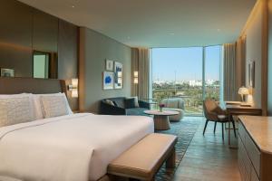 クウェートにあるThe St. Regis Kuwaitのベッドとリビングルームが備わるホテルルームです。