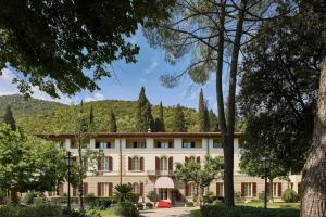 an exterior view of a building with trees at Grotta Giusti Thermal Spa Resort Tuscany, Autograph Collection in Monsummano Terme