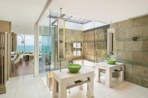 a bathroom with two sinks and a shower with the ocean at W Bali - Seminyak in Seminyak
