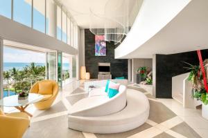 uma sala de estar com um sofá branco e cadeiras em W Bali - Seminyak em Seminyak