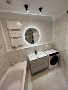 a bathroom with a sink and a washing machine at Sundeck City Centre Apartment in Bratislava