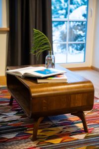 - une table basse avec un livre et une plante dans l'établissement Agluonenai Park Apartments, à Agluonėnai
