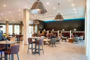 a restaurant with tables and chairs in a lobby at Courtyard by Marriott Mesa at Wrigleyville West in Mesa
