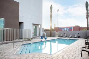 uma piscina com cadeiras e um edifício em Courtyard by Marriott Mesa at Wrigleyville West em Mesa