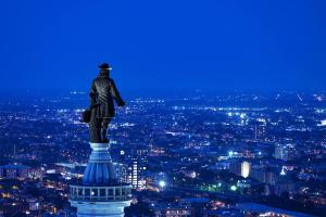uma estátua de um homem no topo de um edifício à noite em W Philadelphia em Filadélfia