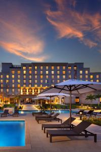 un hotel con mesas y sombrillas y una piscina en The Santa Maria, a Luxury Collection Hotel & Golf Resort, Panama City, en Panamá