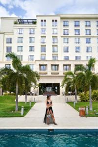 a woman poses in front of a building at The Santa Maria, a Luxury Collection Hotel & Golf Resort, Panama City in Panama City