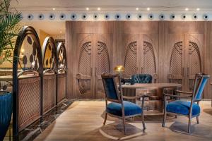 a restaurant with wooden walls and blue chairs at Palacio Santa Clara, Autograph Collection in Valencia